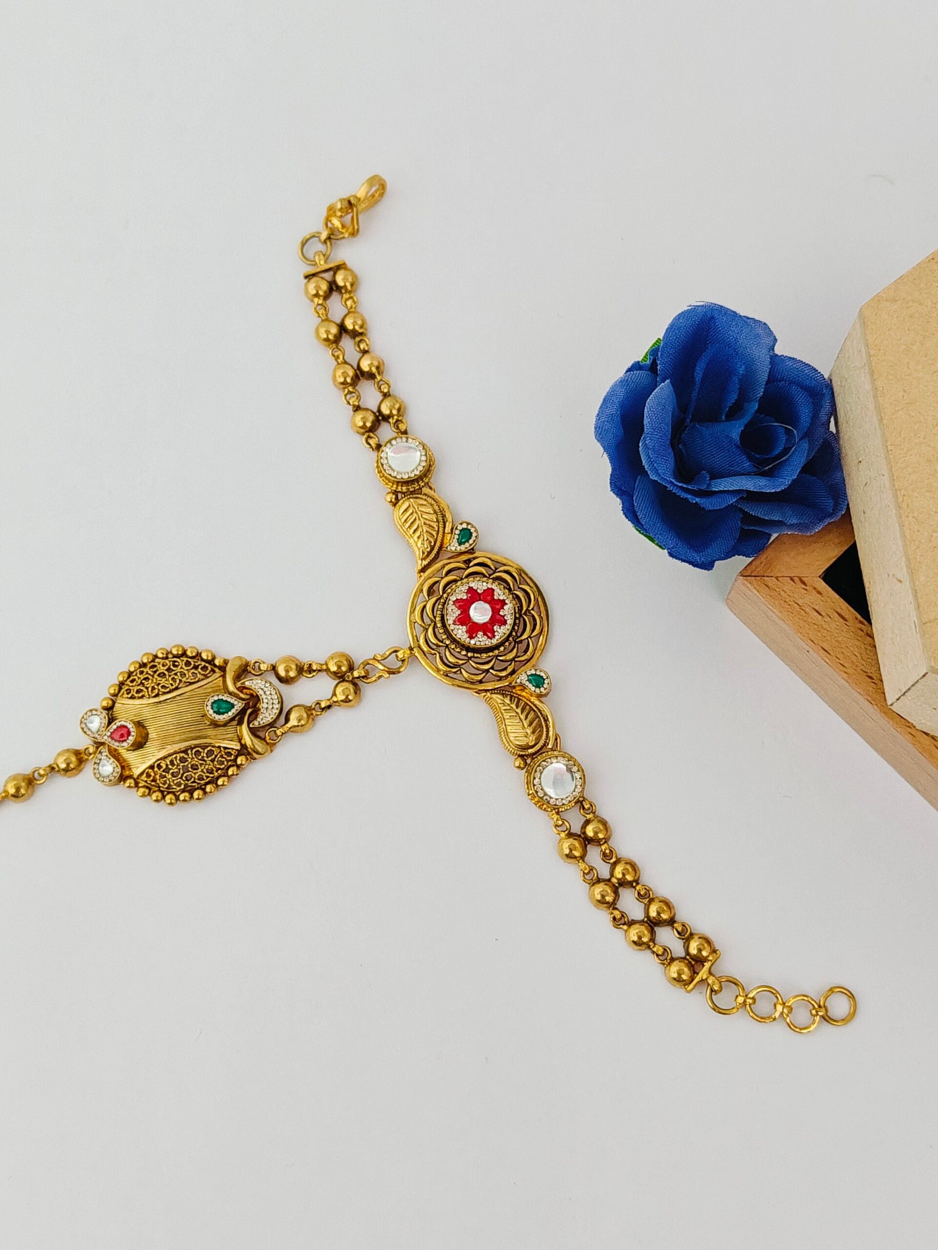 Gold bracelet with decorative elements on a white background